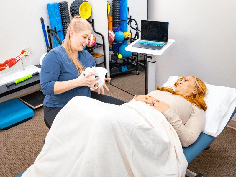 a movementx pelvic floor physical therapy in durham north carolina specialist working with a postpartum mom to treat her pelvic pain in a PT clinic setting