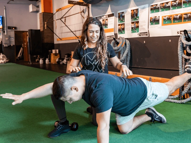 a movementx physical therapist in portland oregon working with a male patient with low back pain in a gym setting