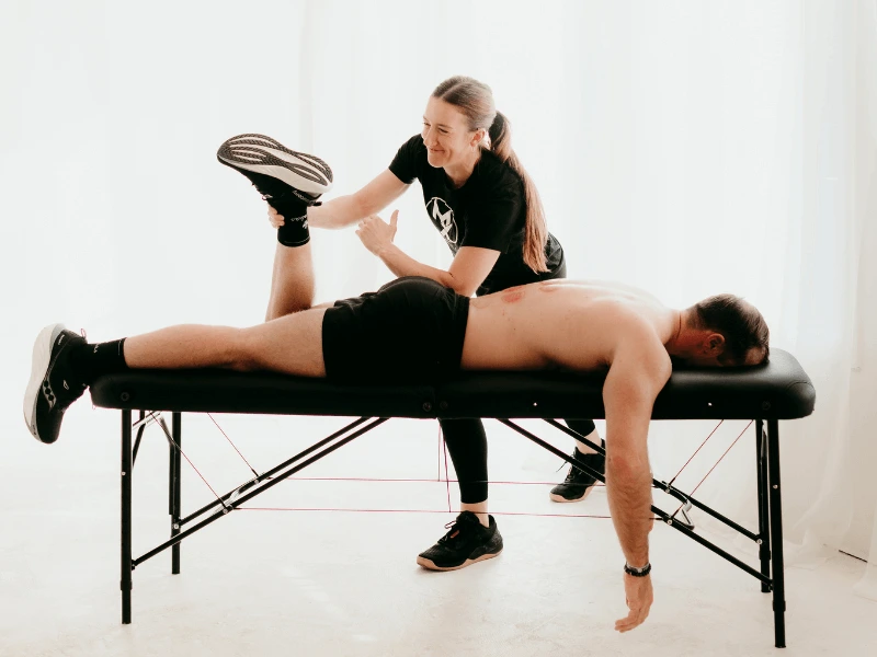 a movementx physical therapist in raleigh-durham north carolina working with a male patient for low back pain treatment in a bright PT clinic setting