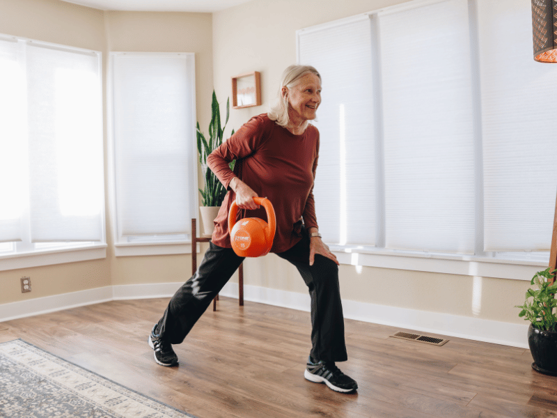 A MovementX patient doing kettlebell rows in their home.