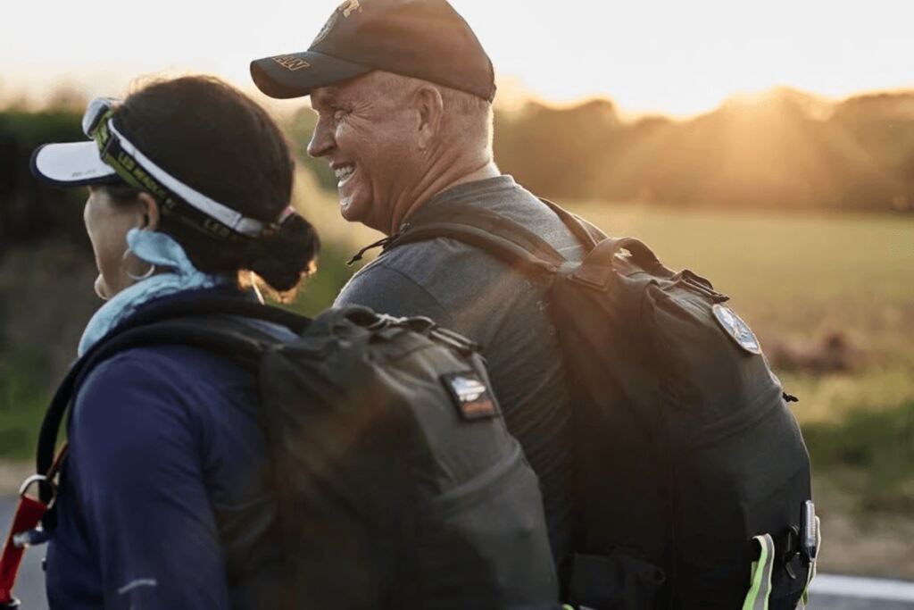 A couple rucking together at sunrise.