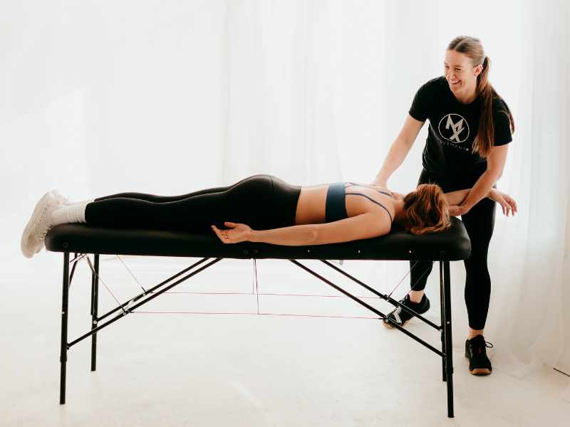 Cali Pyzdrowski, PT, DPT helping a MovementX patient with lower back mobility in North Carolina on a treatment table.