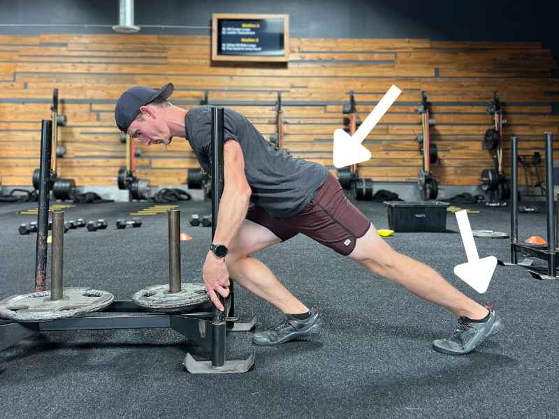 Dr. Chris MonPere performing a sled push stretch in Orange County to prep for the Hyrox competition