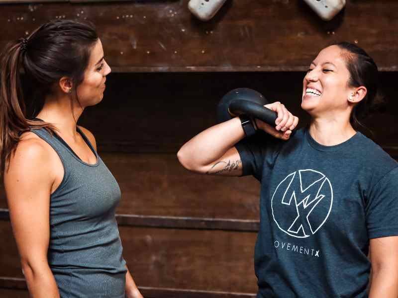 Jessica Crowder, PT, DPT in Huntington Beach helping a patient learn how to rack carry a kettlebell.