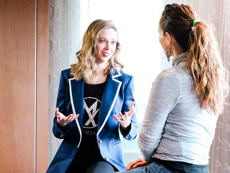 Dr. Stephanie Weyrauch discussing the importance of pelvic health with a woman on a treatment table.