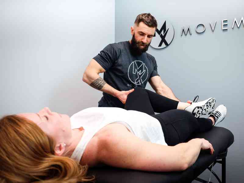 Dr. Matt Szymanski helping a patient kickstart their recovery in a MovementX treatment session.