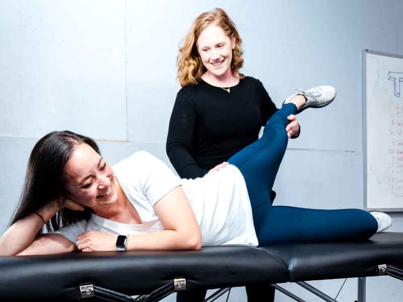 McCaul Butcher, PT, DPT helping a patient with hip mobility on a treatment table in Leesburg, VA