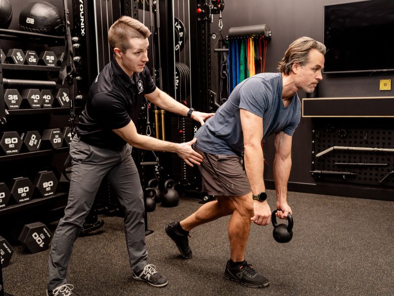 Adam Kays, PT, DPT with MovementX helping a patient work through a series of low back exercises in Noblesville, Indiana