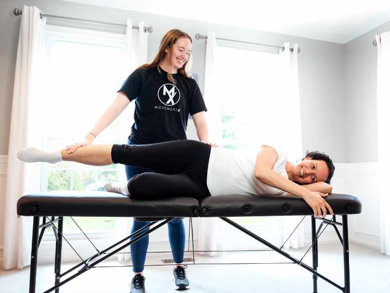 Morgan Groover, PT, DPT helping a patient in Northern Virginia maneuver through a POTS routine on a treatment table.