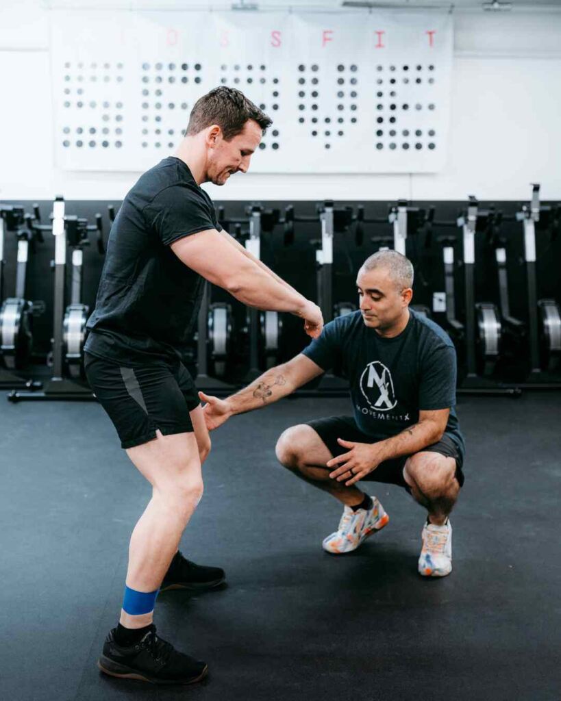Romin Ghassemi, PT, DPT helping a patient do lateral walks in a treatment session in a gym in North Carolina.