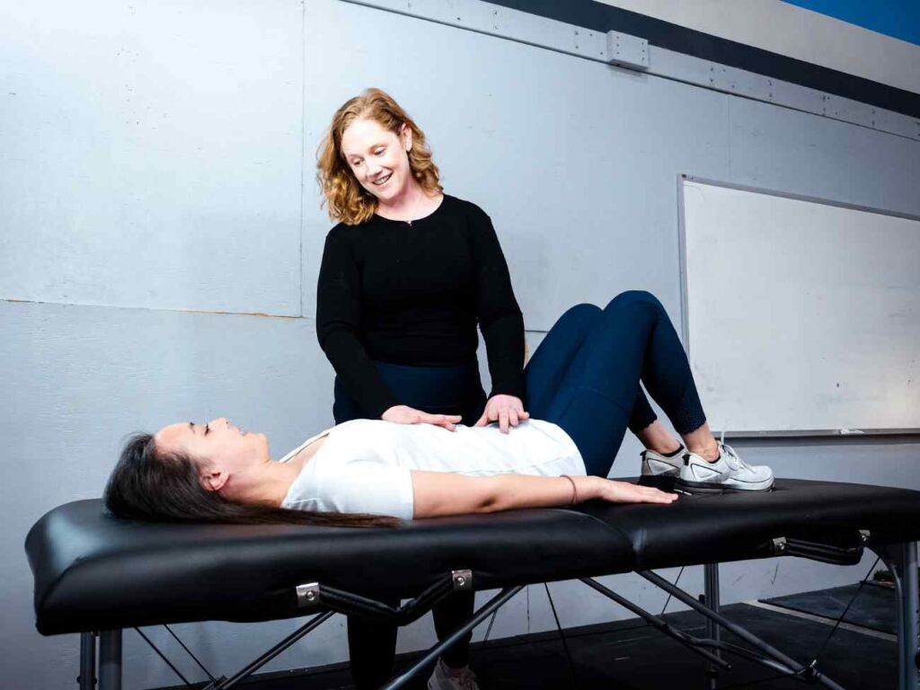 MovementX provider McCaul Butcher, PT, DPT helping a female patient identify and diagnose pelvic health pain during a session in Leesburg, VA.
