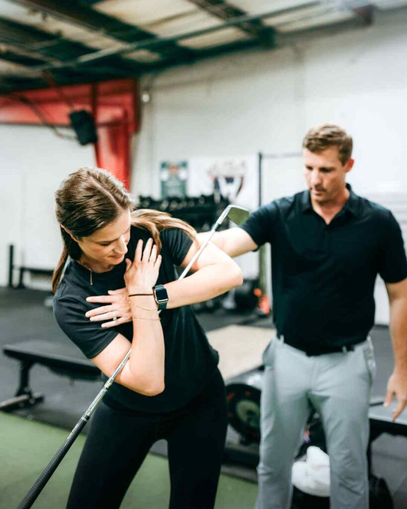 Tyler Eubanks, PT, DPT helping a patient through a thoracic mobility exercise for golf during a session in Durham, NC.