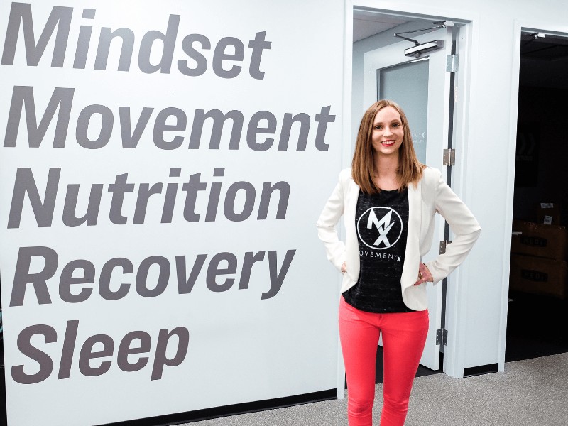 movementx physical therapist standing in front of a wall in a PT clinic