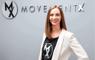 movementx physical therapist in billings mt standing in front of a movementx logo after accepting a pt job in billings mt