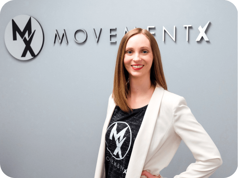 movementx physical therapist in billings mt standing in front of a movementx logo after accepting a pt job in billings mt