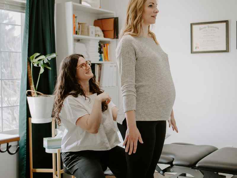 A MovementX provider assessing a pregnant female patient during a private physical therapy session in-home.