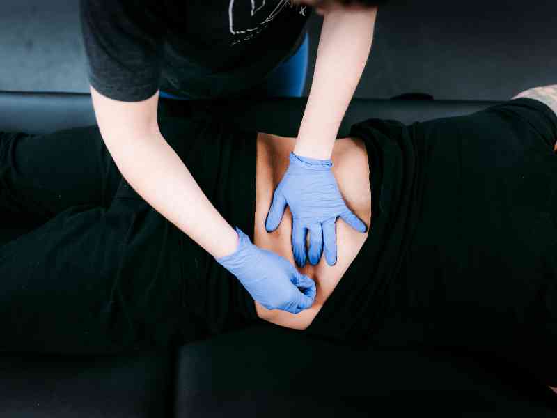 A MovementX provider helping a car accident patient recover with lower back manipulation and release.