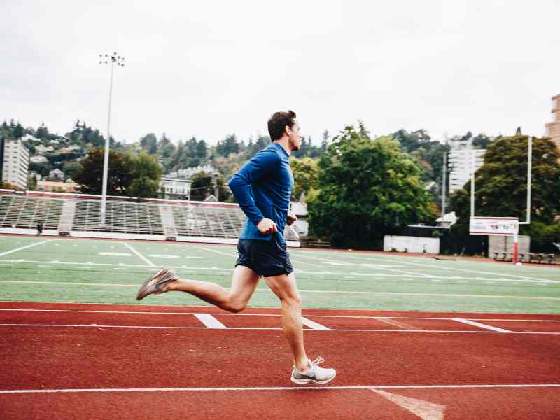 A MovementX patient mid-stride, running on an outdoor track.