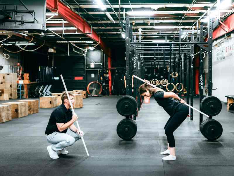 MovementX Physical Therapist, Doctor Tyler Eubanks helping a patient do spinal alignment checks in a gym in Raleigh, North Carolina