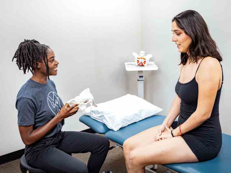 MovementX Doctor of Physical Therapy, Bridget Ochuko, consulting a patient on female pelvic anatomy during a physical therapy session in Durham, North Carolina.