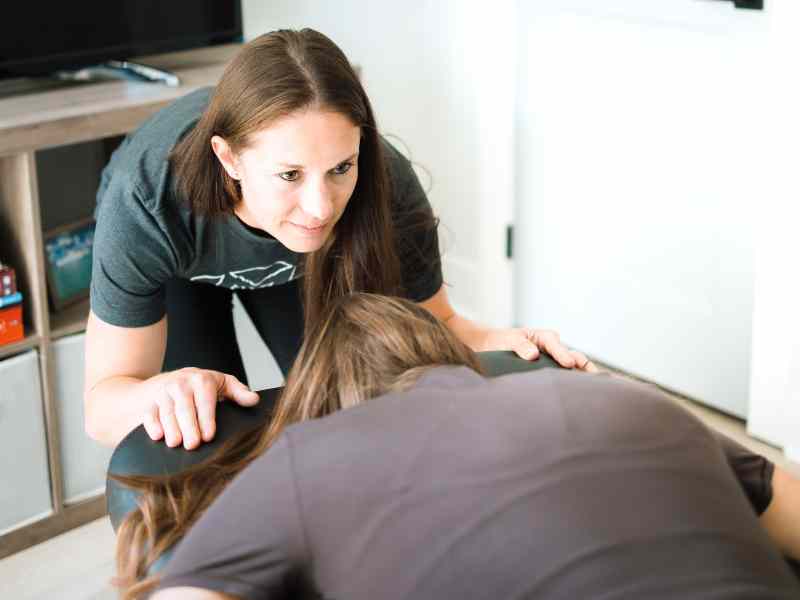 MovementX physical therapist, Jillian Chiappisi PT, DPT evaluating a patient's spinal and rib alignment in-home in Knoxville, TN