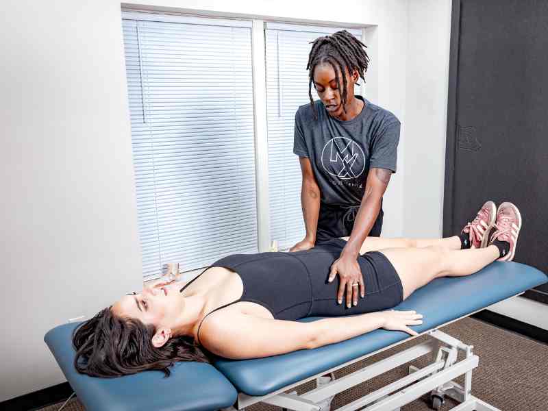 MovementX physical therapist Bridget Ochuko, PT, DPT testing a patient's pelvic floor strength and mobility on a treatment table