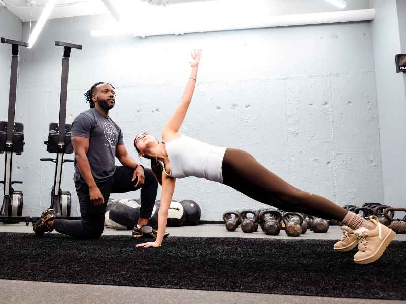 MovementX Provider Anthony Joseph, PT, DPT helping a patient move through isometric calisthenics during a physical therapy session.