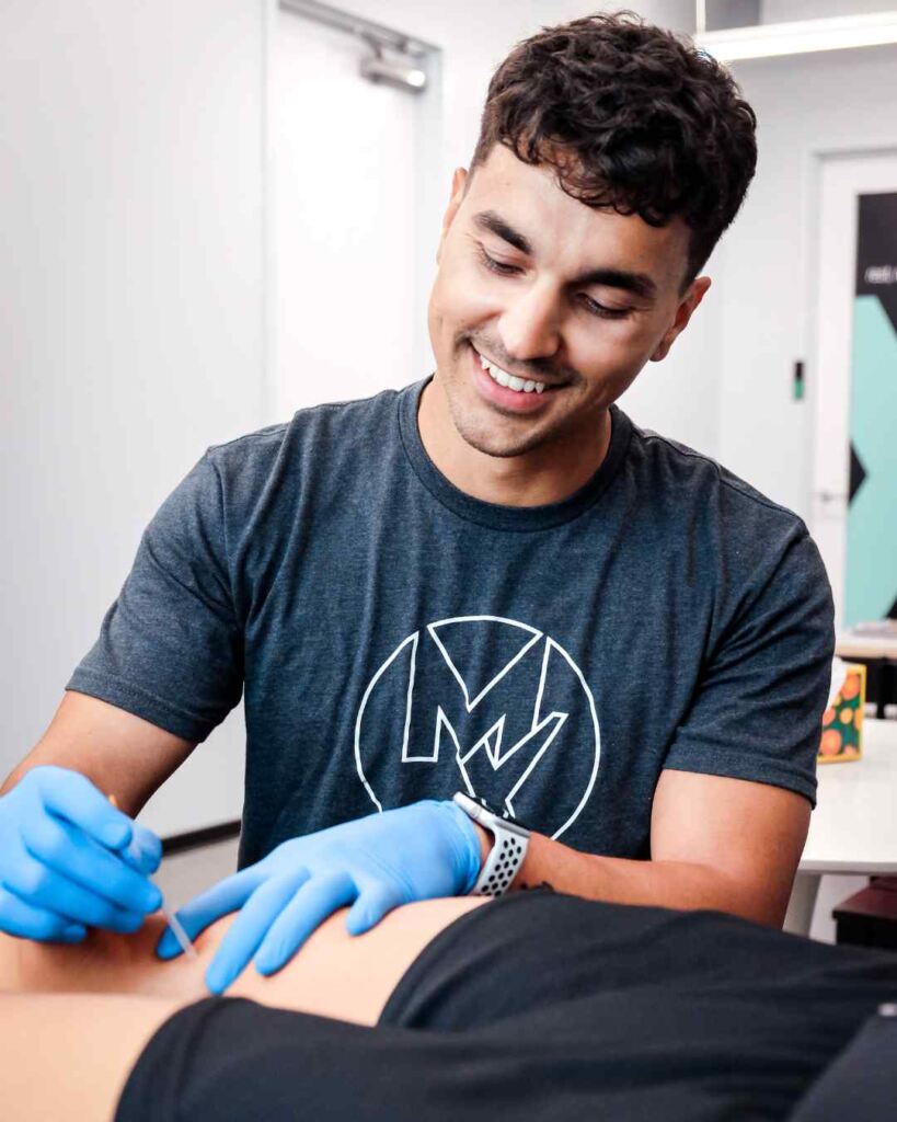 MovementX provider Cesar Laboy, PT, DPT helping a patient during a session with dry needling.