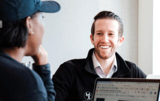 Josh D'Angelo CEO of MovementX smiling while meeting with a Physical Therapist Employee