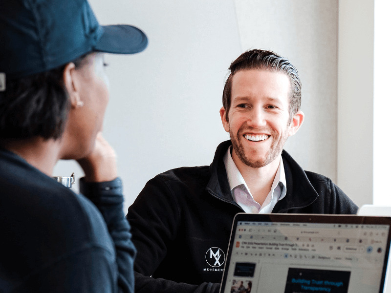 Josh D'Angelo CEO of MovementX smiling while meeting with a Physical Therapist Employee