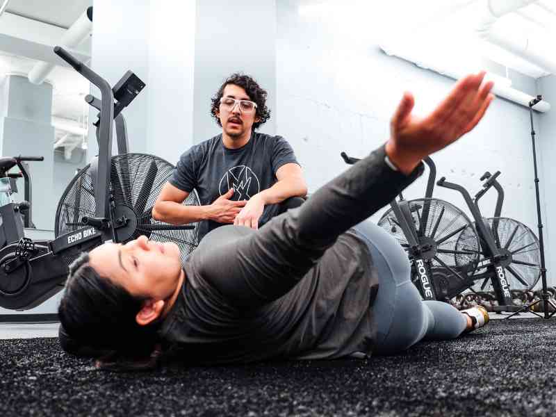 Rich Ortiz, PT, DPT helping a patient mobilize her lumbar and mid-spine during an in-home session in Washington D.C.