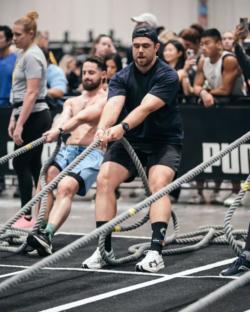 James Cousler, PT, DPT doing rope sled pulls during a Hyrox race.