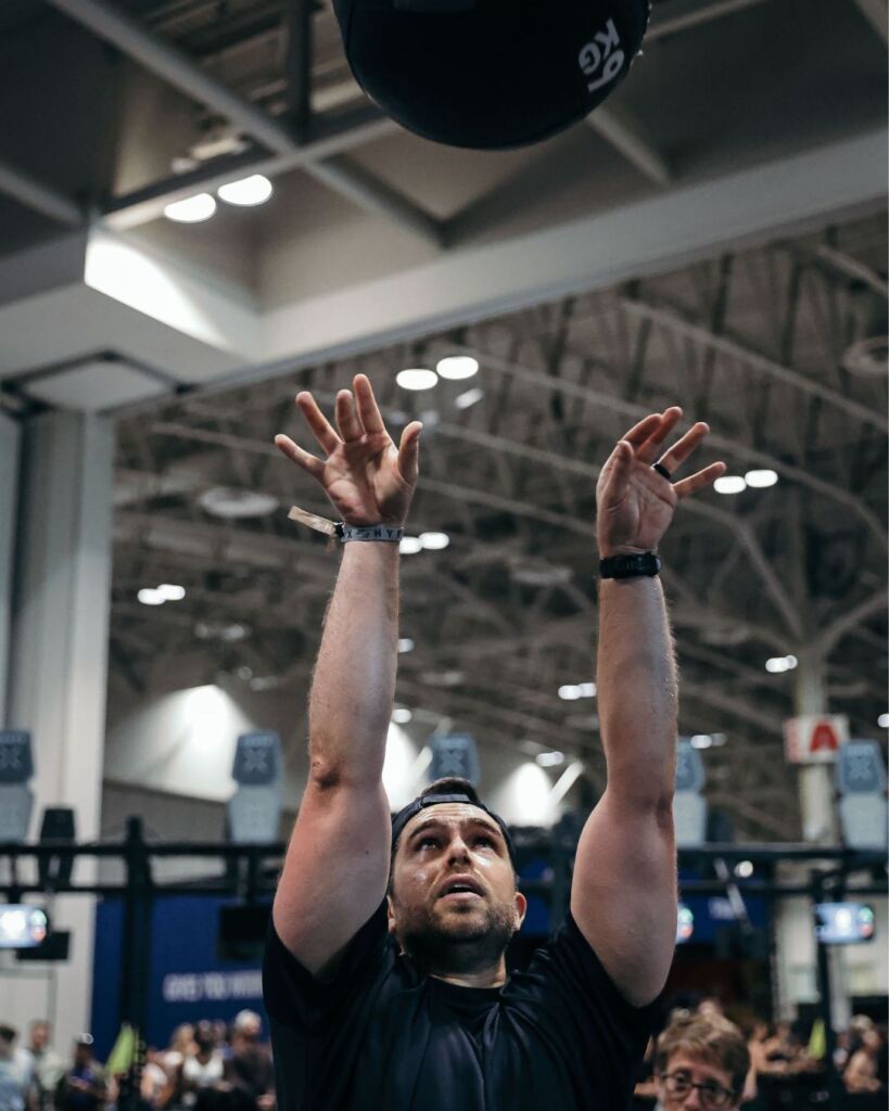 James Cousler, PT, DPT doing med ball throws during a Hyrox race.