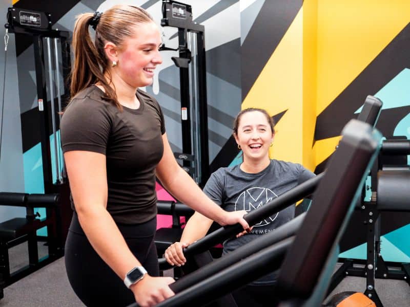 A MovementX physical therapist helping and supporting a patient doing gait exercises on a treadmill in their local gym.