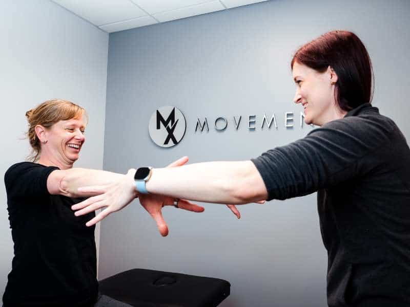 MovementX provider Colleen Gallagher, PT, DPT testing a patient's shoulder mobility and strength.