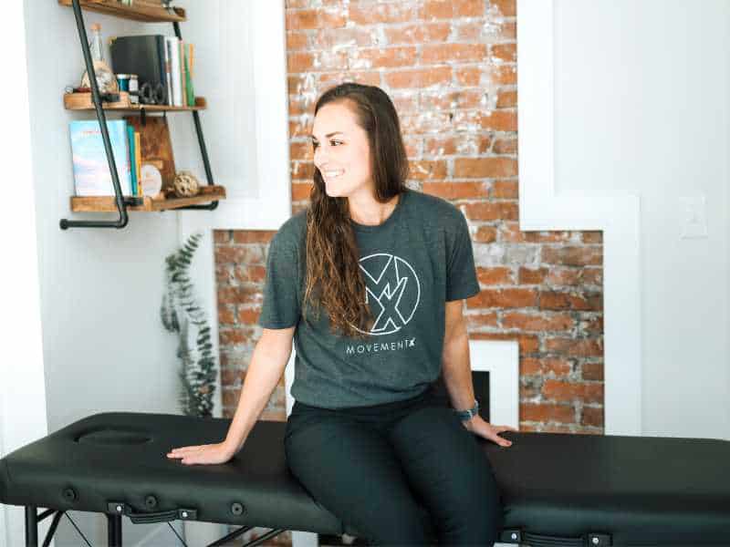 Doctor of Physical Therapy, Ashton Grimm sitting on a treatment table in Knoxville, Tennessee