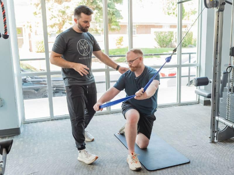 Ryan Krueger, PT, DPT in Indianapolis, IN helping a patient do a rotational cable drill during a PT session.