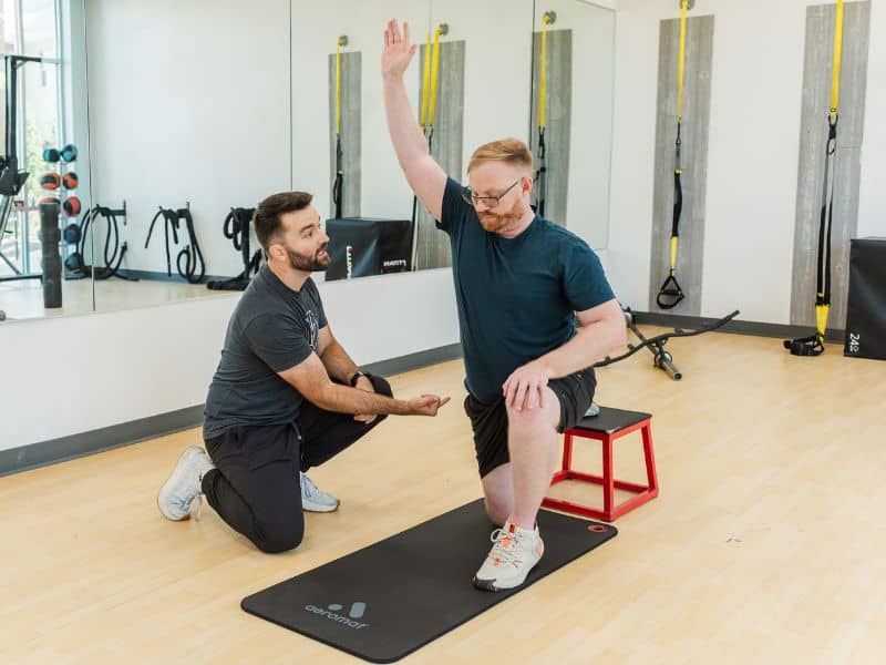 Ryan Krueger, PT, DPT in Indianapolis, IN helping a patient do an isometric stabilization drill during a PT session.